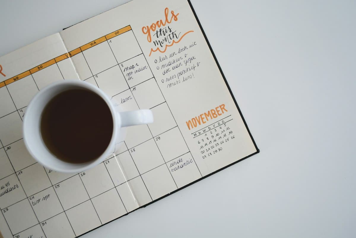 Agenda ouvert avec objectifs du mois et tasse de café