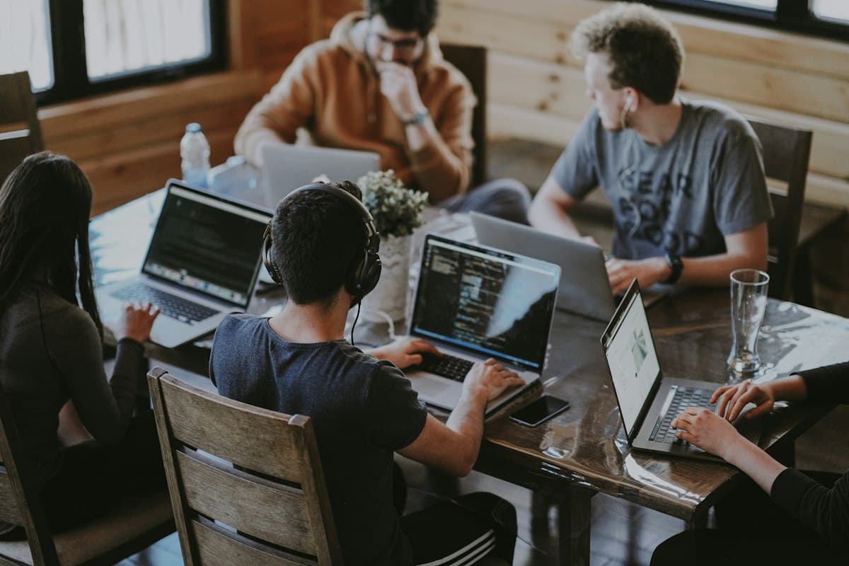 Équipe travaillant sur ordinateurs portables autour d’une table